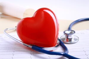 Red heart and a stethoscope on desk