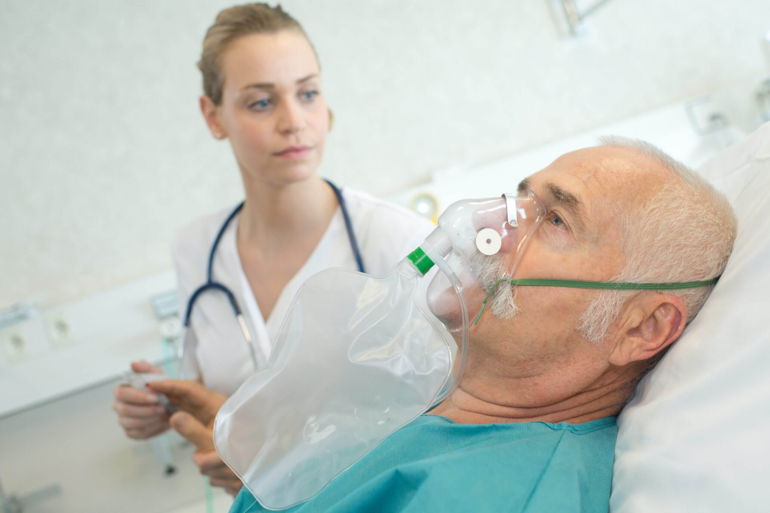 close up of senior man using oxygen mask with nurse