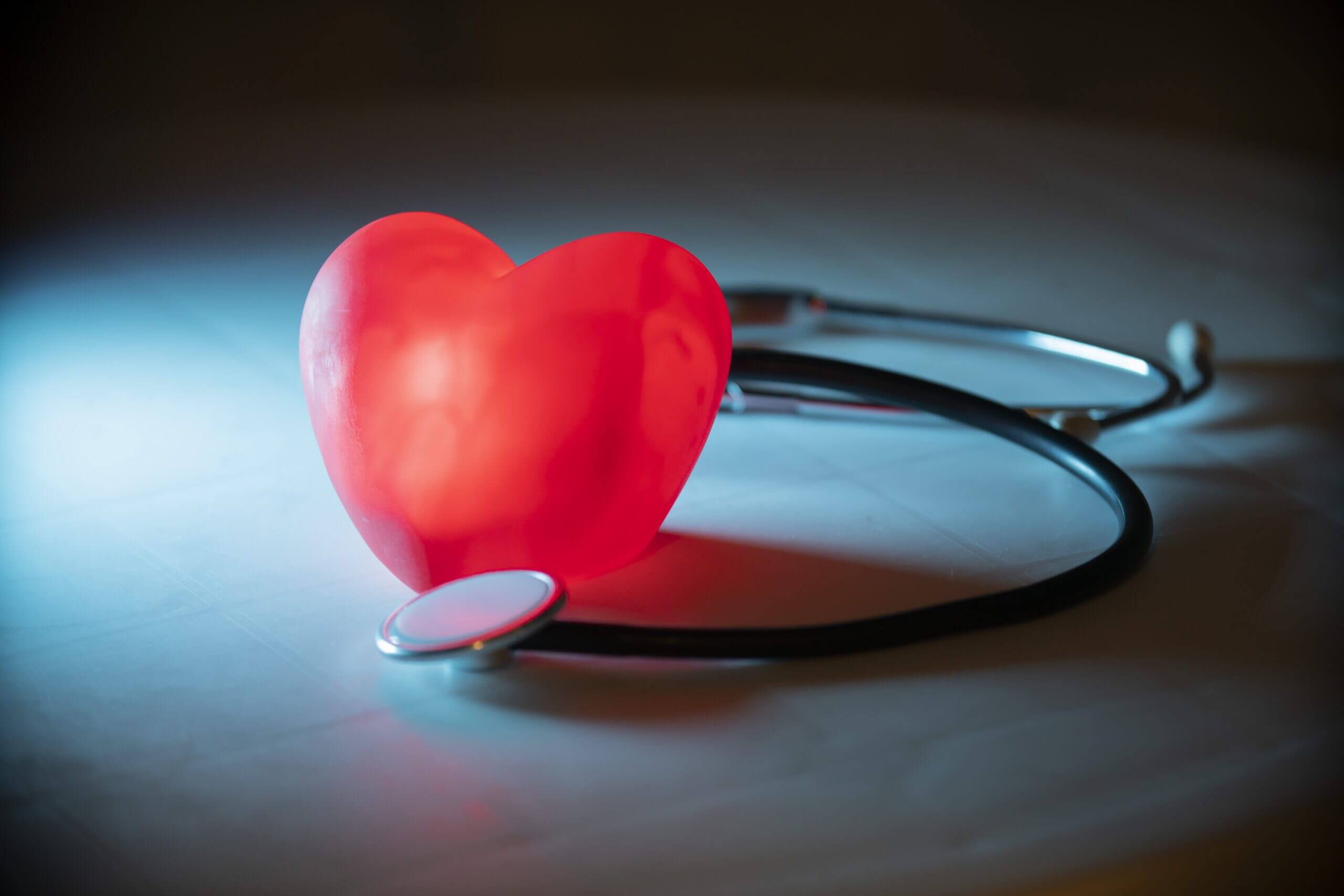 Red heart with stethoscope on blue background
